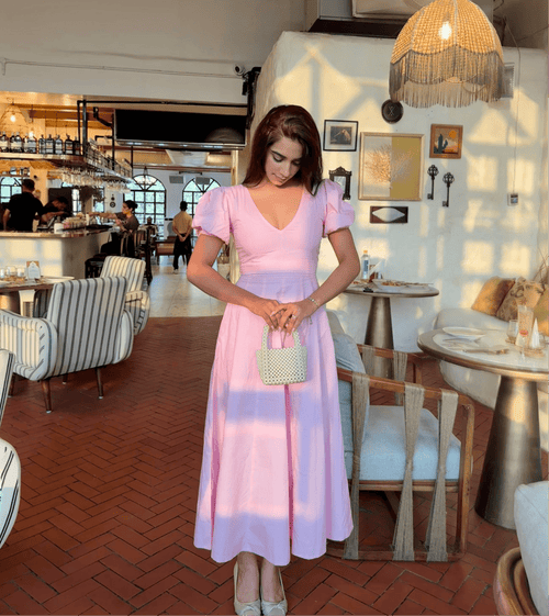 Deep V-neck neckline detail on pink pleated cotton maxi dress
